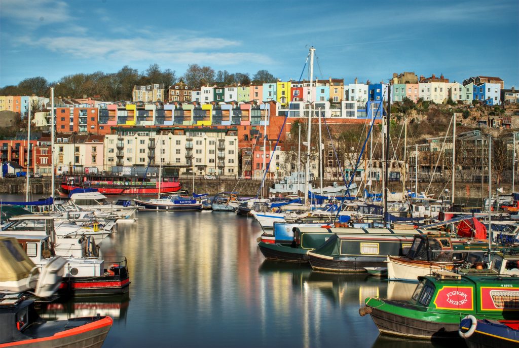 Photo of Bristol Marina with docked boats and colourful houses in the background.