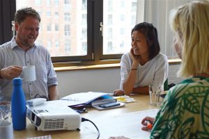 Picture of three people having a discussion