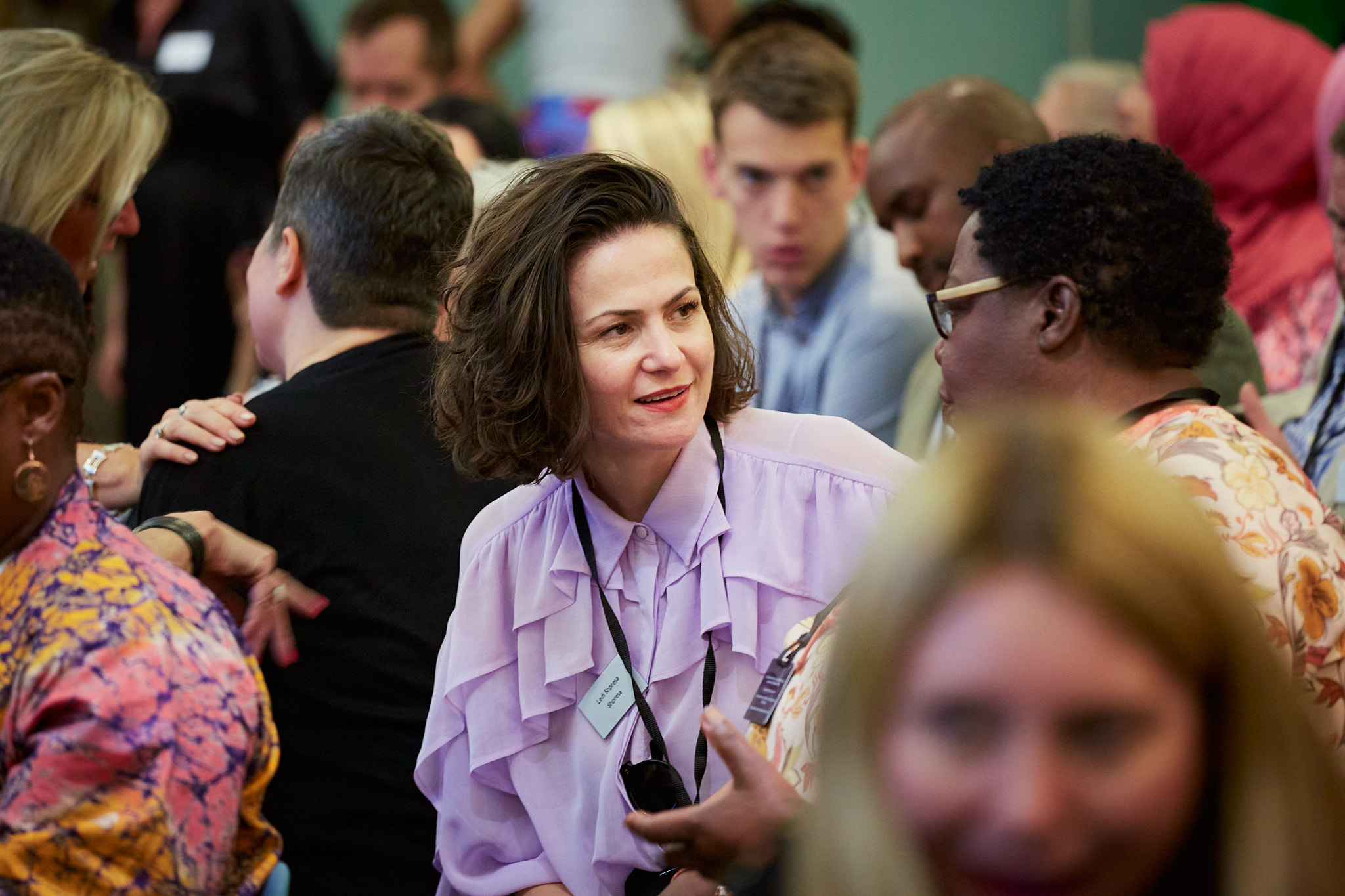 Photograph showing diverse range of people in enthusiastic discussion.