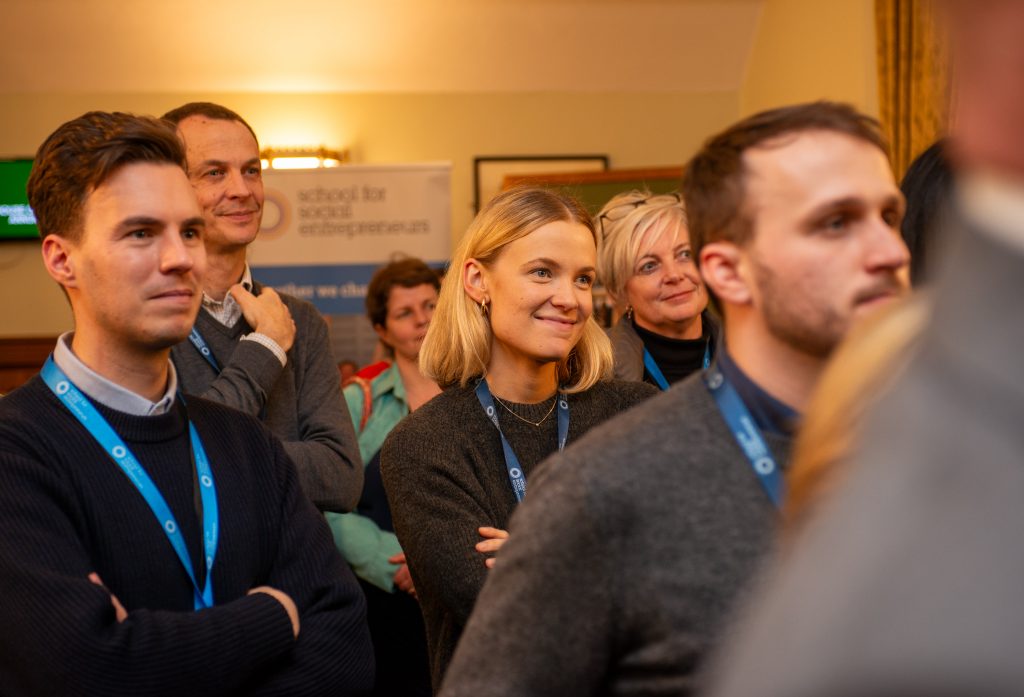 People in a small crowd listening to a speech