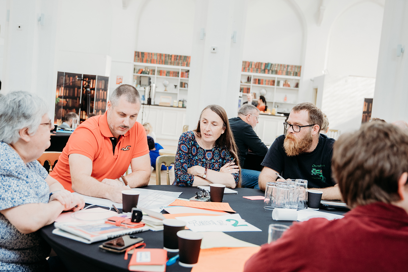 a group people working at a table on a project together
