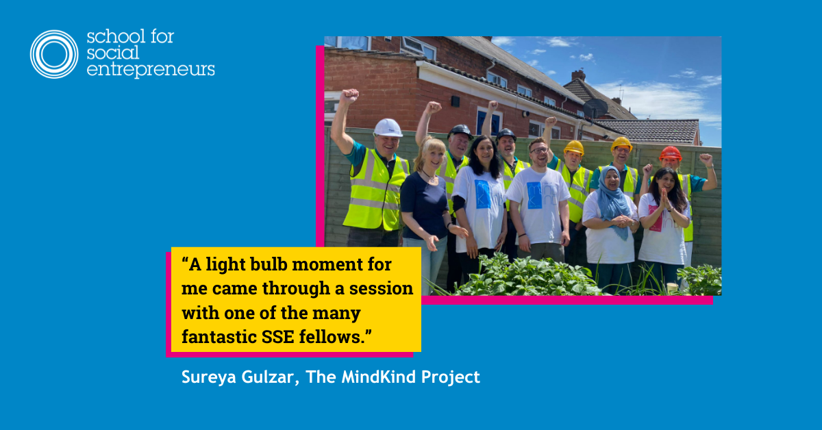A group of people some in hi viz and PPE stand in a group smiling and celebrating outside