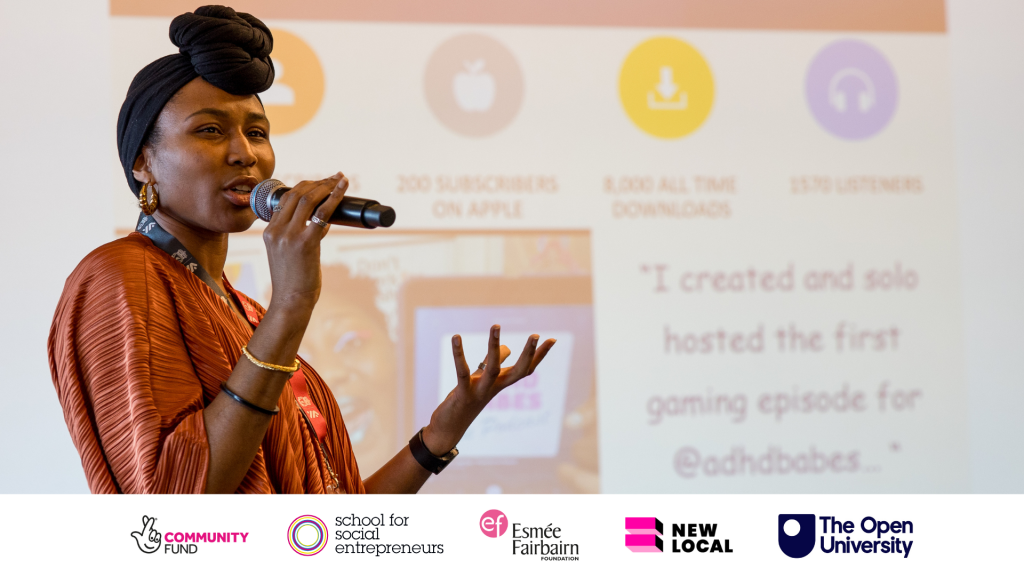 A person speaks into a microphone with a powerpoint presentation behind them